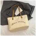 Dettaglio borsa tote minimalista in tela su blazer grigio con manici marroni - Beige e Cachi
