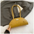 Close-up of yellow crocodile texture shoulder bag featuring a sleek metal brand plaque - Brown
