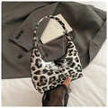 Detailansicht der glänzenden Handtasche mit Leopardenmuster und silberner Metallkette - Weißes Leopardmuster