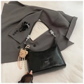 Detalle de bolso de hombro negro textura cocodrilo con correa de cuentas y colgante oso - Negro