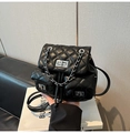 Vue détaillée du sac à dos matelassé noir avec chaîne en argent et fermoir rotatif - Noir