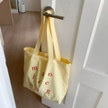 Light yellow canvas tote bag with red letter print and long handles for daily commute - Yellow