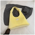 Detail of light yellow velvet tote bag with branded fabric label on a neutral background - Yellow