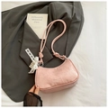 Close-up of light pink embossed hobo bag with white lace bow and pearl pendant details - Pink