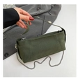 Close-up of a dark green suede handbag featuring silver chain strap and metal ball clasp - Green