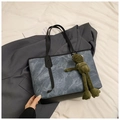 Dettaglio della borsa tote effetto marmo denim con manici in pelle nera e ciondolo a rana - Con Ornamento / Blu