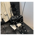 Détail du sac à main en cuir verni noir avec rivets argentés sur le grand nœud décoratif - Noir