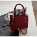 Dettaglio borsa bordeaux elegante con bordi a onda e ciondolo a forma di ciliegia rossa - Borgogna