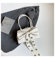 Creamy white handbag featuring a large bow with silver studs and polished leather finish - White