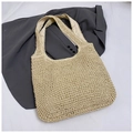 Dettaglio ravvicinato della trama della borsa tote in paglia e manico su abito grigio - Beige