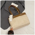 Detail einer großen Stroh-Tote-Bag mit braunem Lederbesatz und süßem Plüschbären-Anhänger - Braun Mit Anhänger