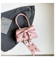 Pink bow handbag with silver studs in a trendy minimalist studio setting photography - Pink