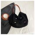 Dettaglio della borsa tote nera intrecciata con fiocchi colorati e manici in pelle marrone - Nero