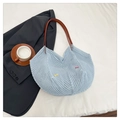 Dettaglio della borsa crochet celeste con fiocchi colorati e tracolla in pelle marrone - Blu