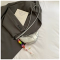 Détail du sac croissant argenté avec perles colorées posé sur un blazer gris chic - Argent avec pendentif