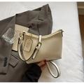 Detail der cremefarbenen Beuteltasche aus Leder mit Lychee-Muster und Goldbeschlägen - Gebrochenes Weiß