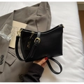 Detail der schwarzen Beuteltasche aus genarbtem Leder mit goldenen Beschlägen - Schwarz
