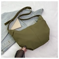 Close-up of olive green corduroy crescent bag texture on casual denim jacket background - Green