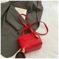Dettaglio mini borsa rossa in pelle a grana con logo dorato e ciondolo a nodo - Rosso