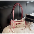 Détail du sac crème avec lanières en cuir rouge et nœuds décoratifs élégants - Blanc Cassé
