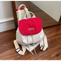 Detalle de la solapa roja con logo y correas ajustables en la mochila de nailon - Burdeos