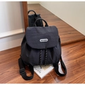 Detalle de la mochila de nailon que muestra el cierre de cordón y el parche del logo - Negro