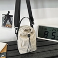 Borsa a secchiello beige chiaro con coulisse, tracolla nera regolabile e texture fine - Bianco