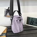 Borsa a secchiello viola chiaro in nylon testurizzato con tracolla nera regolabile - Viola