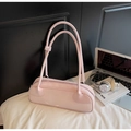 Vista de detalle del bolso baguette rosa rectangular con asas finas sobre fondo de tela - Rosa