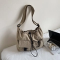 Detail of khaki waterproof nylon shoulder bag with drawstring closure and buckle pockets - Khaki