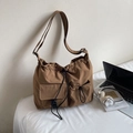 Detail view of large nylon shoulder bag with adjustable strap and drawstring pockets - Coffee