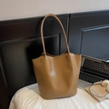 Close-up of brown crocodile embossed leather tote bag with long shoulder straps - Khaki