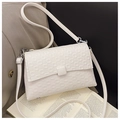 Detail of white rectangle crossbody bag showing small square embossed texture and leather buckle - White