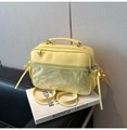 Detail der gelben glänzenden PVC-Umhängetasche mit transparenter Tasche und Griff - Gelb