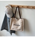 Japanische Canvas-Tasche in Cremeweiß mit braunen Ledergriffen und grafischem Buchstabendruck - Beigegrau