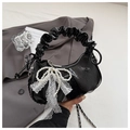 Detail of black patent leather cloud bag with pearl bow and lace ribbon accent - Black