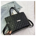 Dettaglio della borsa shopper trapuntata nera con texture lucida e logo metallico - Nero