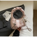Detail of light pink moon bag featuring pleated handle and pearl bow charm accessory - Pink With Charm