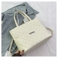 Dettaglio della trama trapuntata e targhetta logo in metallo argento su borsa bianca - Bianco Sporco