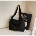 Détail d'un sac bandoulière noir minimaliste en toile avec sangle réglable sur table - Noir