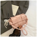 Détail du sac bandoulière rose en cuir PU tissé avec logo argenté et breloque en dentelle - Rose