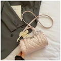 Detail der hellrosa gesteppten Zylindertasche mit Spitzenschleife und Silberverschluss - Rosa