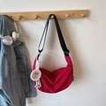Detalle de bolso media luna rojo en nailon con colgante de dibujos y correa ajustable - Con Colgante / Burdeos