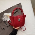 Rote geflochtene Eimertasche mit Metallverschluss und Doppelgriff auf grauem Anzug - Ankara Rot
