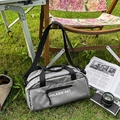 Gray grid texture crossbody sports bag with black handles on a scenic outdoor lawn - Gray