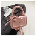 Dettaglio della borsa a mano rosa lucida con fiocco decorativo e ciondolo a sfera - Rosa Con Ciondolo