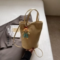Chic yellow crocodile embossed bucket bag with pearl doll charm on casual bedding - Yellow
