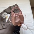 Pink lychee texture bucket bag with woven handle and gold brand lettering detail - Pink