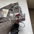Light blue Boston bag with red bow and lace details shown in a lifestyle setting - Blue