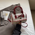 White Boston bag with red polka dots and bow detail featuring a heart-shaped charm - White